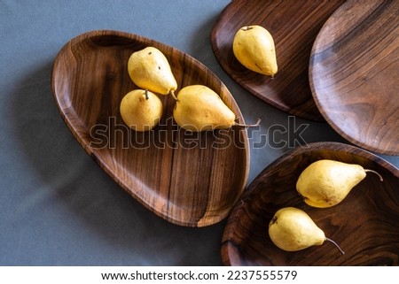Handmade walnut round wooden pallet, wooden chopping board Empty pear gray background  bowl with wood rings Handmade plank texture Tableware dark brown old tray cooking serving