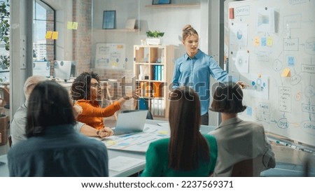 Beautiful Female Manager Holding a Meeting in a Conference Room at a Creative Agency Office. Caucasian Woman Using Whiteboard and Mindmapping Technic to explain Company's Commerce Strategy