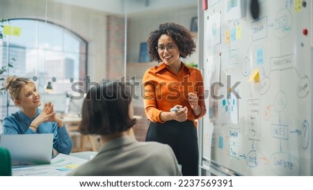 Diverse Office Conference Room Meeting: Successful Black Female Executive Director Presents e-Commerce Fintech Growth Statistics to a Group of Investors. Whiteboard with Big Data Analysis Royalty-Free Stock Photo #2237569391
