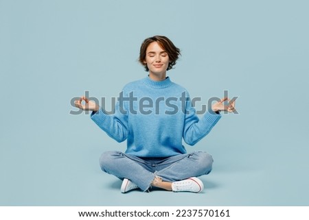 Full body young woman wear knitted sweater holding spreading hands in yoga om aum gesture relax meditate try to calm downisolated on plain pastel light blue cyan background. People lifestyle concept Royalty-Free Stock Photo #2237570161