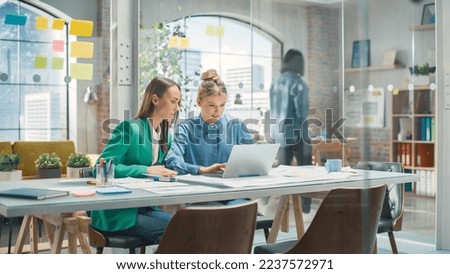 Portrait of Two Creative Colleagues Collaborating and Pointing at the Laptop in Modern Office. Female Manager Consults White Project Manager, They Brainstorm on the Project. Royalty-Free Stock Photo #2237572971