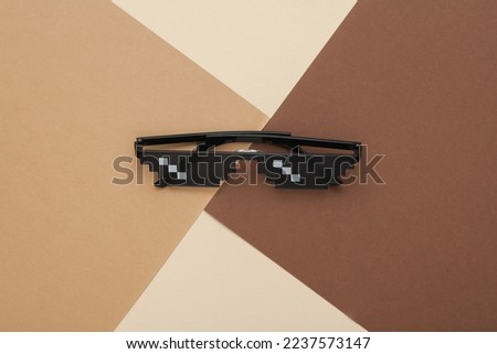 8 bit pixelated sunglasses on a brownish beige background