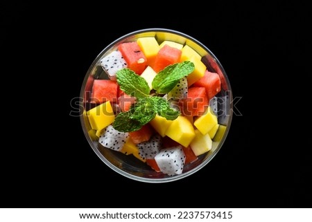 Fruit salad made of east asian fruits isolated on black background top view
