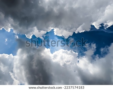 Picturesque sky landscape. A piece of blue sky among the clouds. Background, postcard, wallpaper, sky, nature. Cloudy weather, the sun's rays shine from behind the clouds