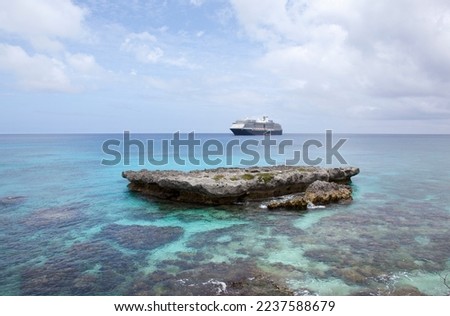 The scenic view of transparent waters on Tadine village beach and a drifting cruise ship in a background (Mare island, New Caledonia). Royalty-Free Stock Photo #2237588679