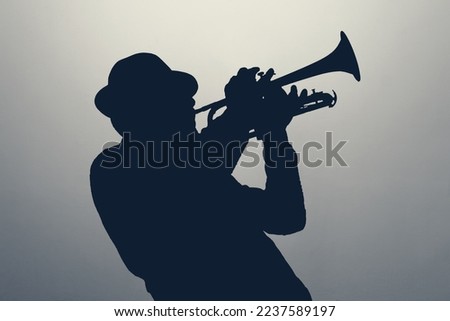 silhouette of a jazz man playing trumpet Royalty-Free Stock Photo #2237589197