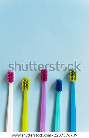 Five Toothbrushes on blue background.