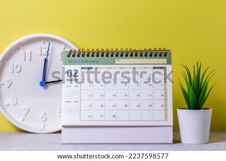 Desktop calendar for February 2023 on the table.