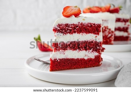 Red velvet cake with fresh strawberries. Festive layered cake from red sponge cakes and cream cheese frosting. American cuisine