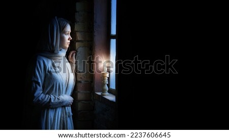 Lone retro rural veil cloth jew holy slave maid life sad poor lady look cry plead bible Jesus. Holy cold kid child think ask beg old biblical god Christ wait even flame light war home room text space Royalty-Free Stock Photo #2237606645