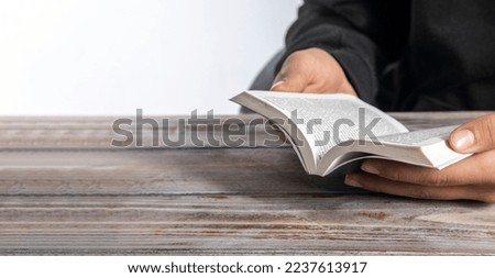 Close up of a man hands praying on the open holy bible 