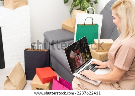Young woman with laptop and shopping bags at home. Black Friday sale