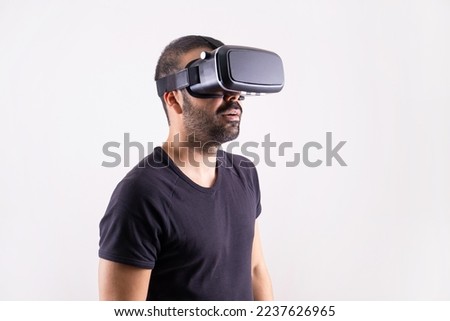 Young man using VR glasses headset, portrait on light background. Virtual reality, future technology, education video gaming.