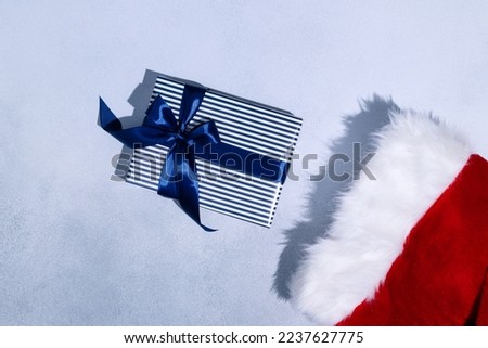 Christmas sock and Christmas gift with blue ribbon on grey background. Space for text. Mockup. High quality photo