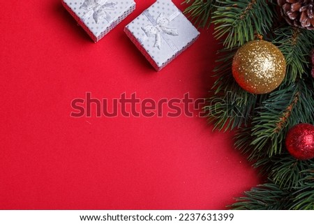 beautiful branches of the Christmas tree with cones and toys on a red background close-up