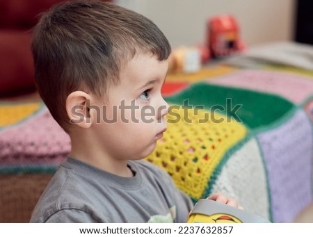 Expressive young boy watching cartoons in the livingroom