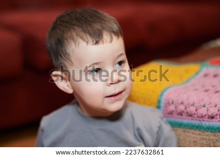 Expressive young boy watching cartoons in the livingroom