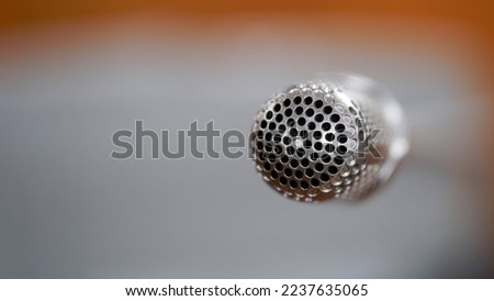 Head-tip of a small microphone for recording sound during streams or speeches at business meetings and negotiations, indoors. Macro. bokeh. Selective focus. Close-up