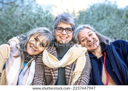 Happy group of mature women with gray hair hugging each other. Three senior female friends having fun good time together Royalty-Free Stock Photo #2237647947