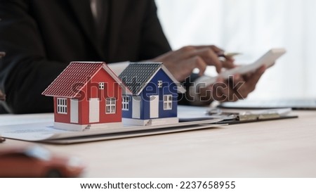 Using calculator, Credit approver, businessman in male suit and house toy model mockup Home loan mortgage approval concept. After signing the contract