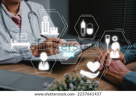 Medical Concept, Critical Care, Doctor and patient are discussing something with Critical Care icon on virtual screen, Medical physician working in hospital writing a prescription. Royalty-Free Stock Photo #2237661437