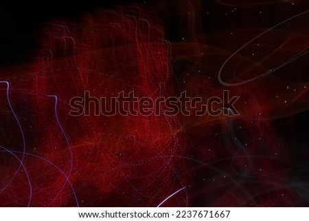 A long exposure photo of red lights heart shaped. There are white light stripes. Copy space.