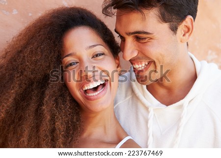 Romantic Couple On Holiday Together Posing By Wall