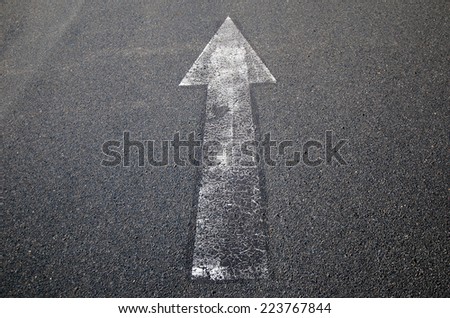 white painted arrow on old road