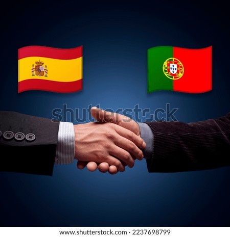 SPAIN AND PORTUGAL flags. Hands of elegant businessmen greeting each other and closing a deal in sign of international agreement.