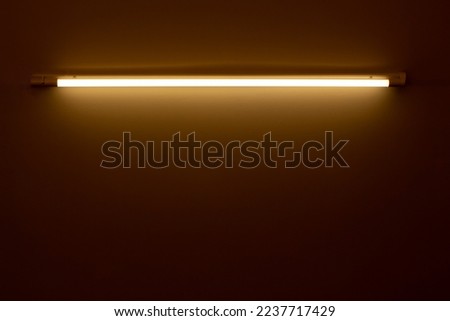 orange neon lamp on a white wall Royalty-Free Stock Photo #2237717429