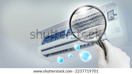Dust and dirty inside of an air conditioner filter through a magnifying glass. Royalty-Free Stock Photo #2237719701
