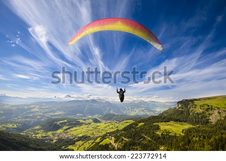 Paraglider flying over mountains in summer day Royalty-Free Stock Photo #223772914