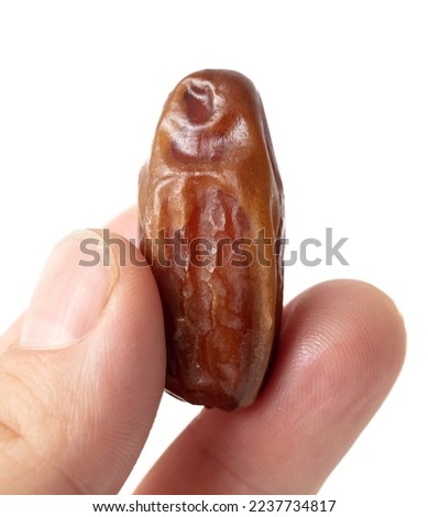 Dried date in hand isolated on white background. Close-up