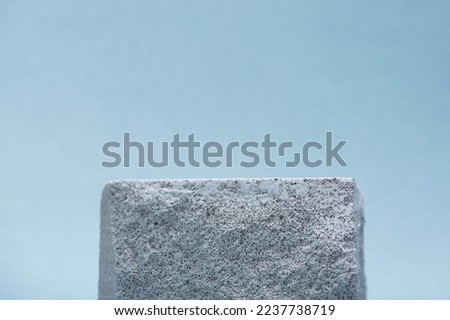 Gray stone podium for cosmetics on a blue background. template for advertising. Minimal pedestal scene.