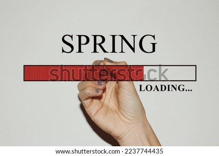 Woman hand with glitter nails showing the Loading Bar with the text “Spring”