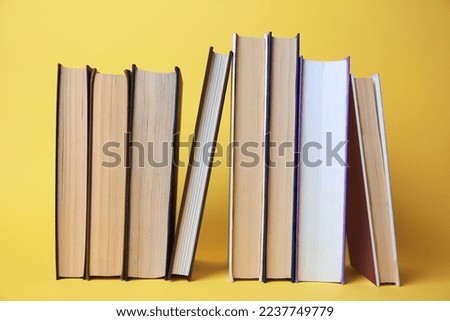 Collection of hardcover books on yellow background