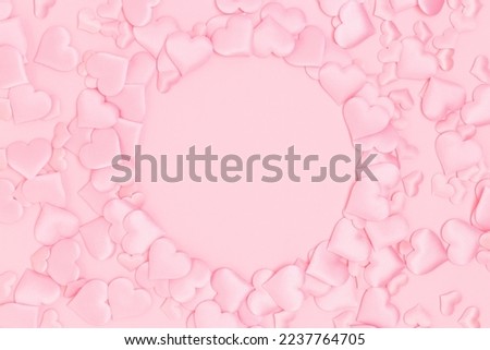 Round frame made of textile pink confetti in a heart shape. Monochrome composition with place for text.