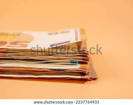 Money on an orange background. Euro paper banknotes. Close-up.