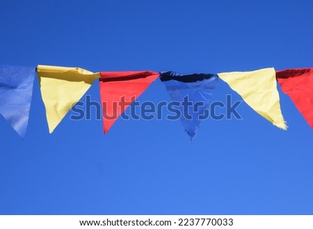 Pieces of colored textile material hung on the wire. Textile material for decoration. Blue sky in the background