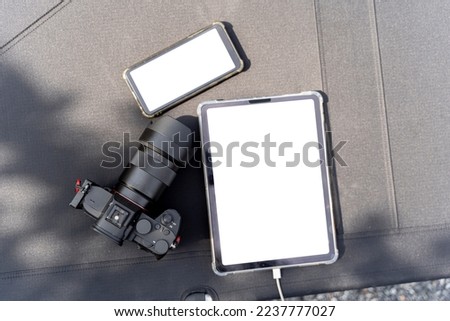 Laptop, phone and camera on black canvas bed. Top view of black table with smartphone, tablet, camera and copy space, include clipping path