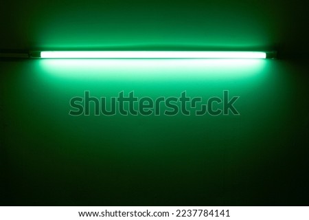 Green neon lamp on a white wall