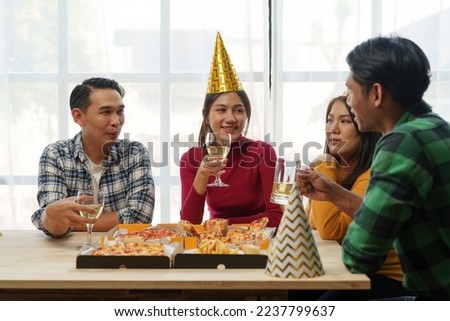Friends at birthday party clinking glasses with champagne and pizza, enjoying Christmas vacation, pizza on the table. Holiday Party event