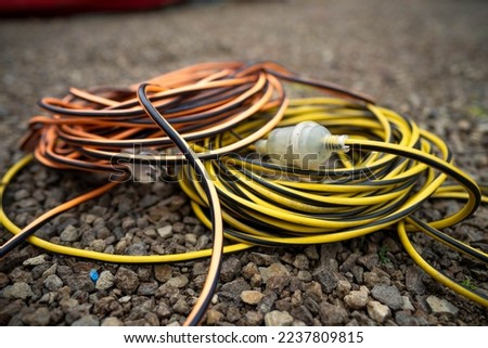 extension cord wrapped up on the ground. extension lead, power lead on a construction site Royalty-Free Stock Photo #2237809815