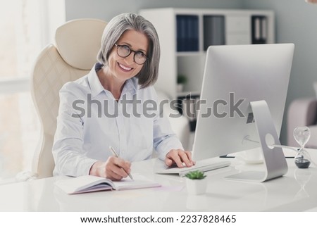 Photo of cheerful smiling lady assistant wear spectacles white shirt planning schedule modern gadget indoors workplace workshop