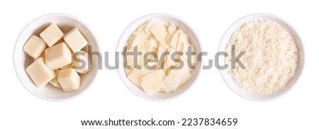 Grana Padano cheese, chunks, flakes and grated, in white bowls. Italian hard cheese, similar to Parmesan, with a savory flavor and a crumbly, slightly gritty texture, made from unpasteurized cow milk. Royalty-Free Stock Photo #2237834659