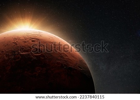 Amazing beautiful planet Mars with craters in stellar space with the sunrise light. 