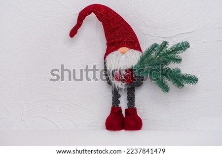 Christmas gnome in red hat with a fir tree in his hands. Decoration for Your Christmas. Christmas and New Year concept, greeting card, copy space