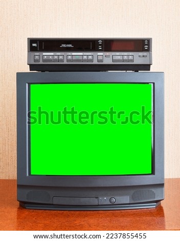 Old vintage TV with green screen to add new images to the screen, VCR on wallpaper background.