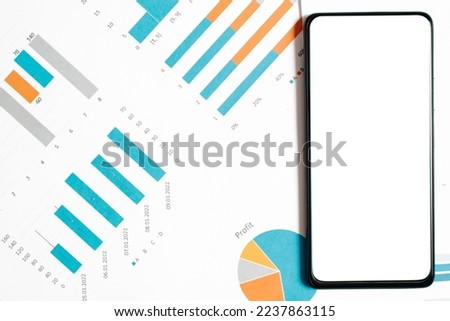 Smartphone mockup on graphs and charts. Top view white blank screen mobile phone workplace.