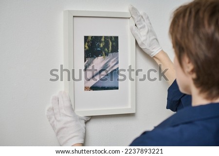 Woman decorating wall with framed photo